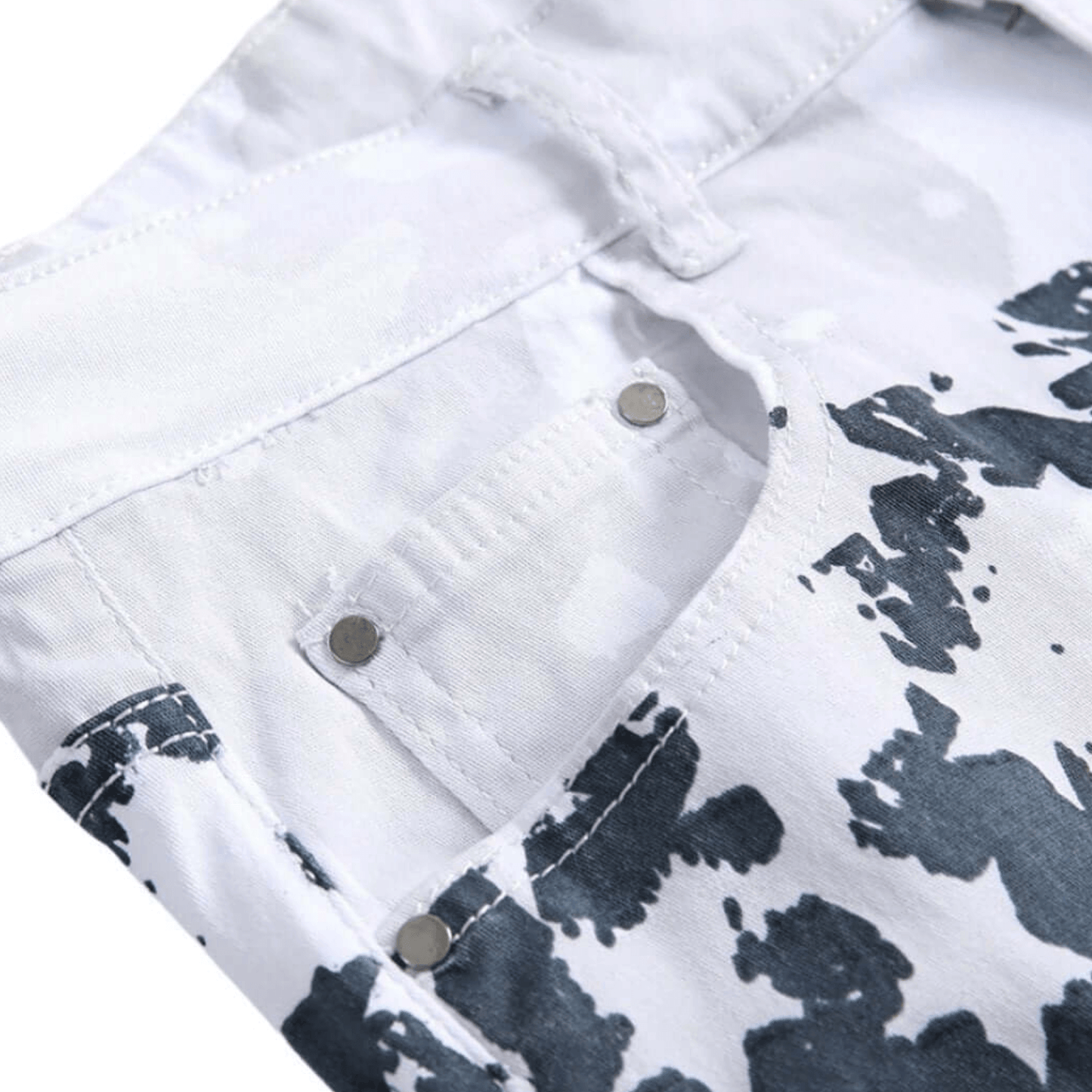 Close-up of stylish white denim fabric with black abstract patterns and metal button details.
