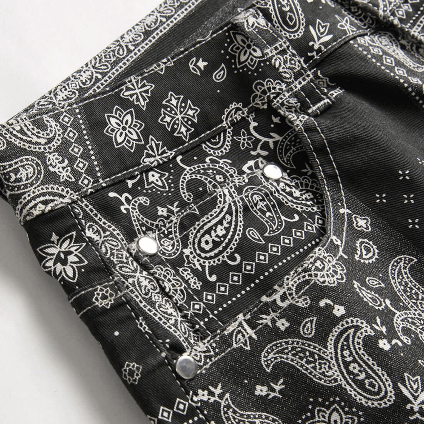 Men's relaxed-fit paisley print denim jeans displaying intricate patterns and premium quality fabric.