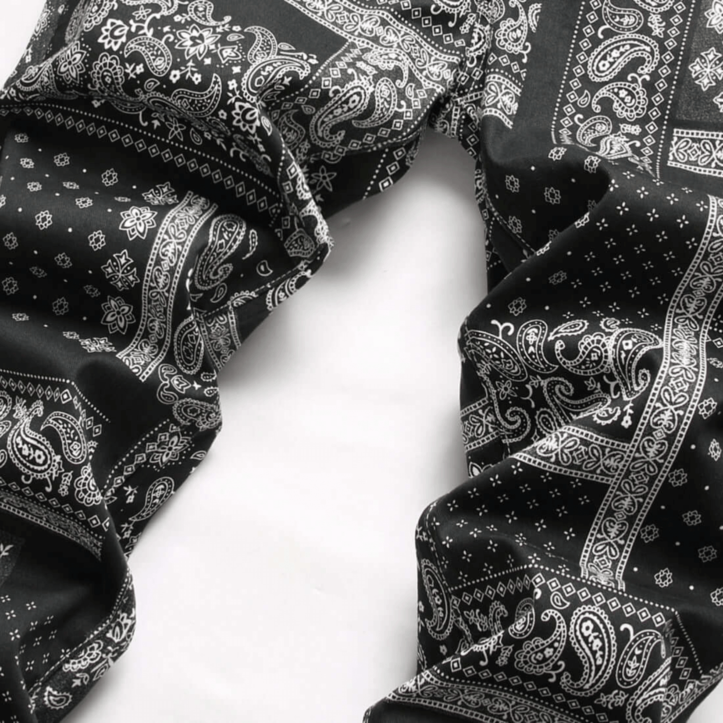 Men's relaxed-fit paisley print jeans in black and white, showcasing premium quality denim and retro urban style.