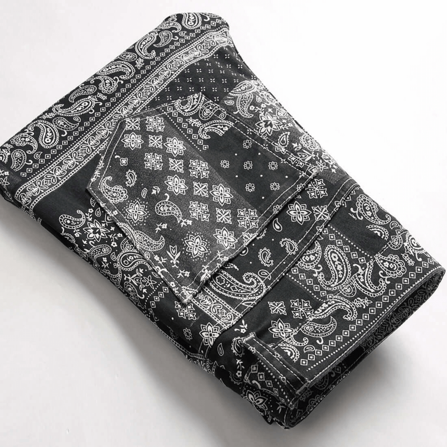 Men's relaxed-fit paisley print jeans in premium black denim, showcasing retro urban style and comfort.