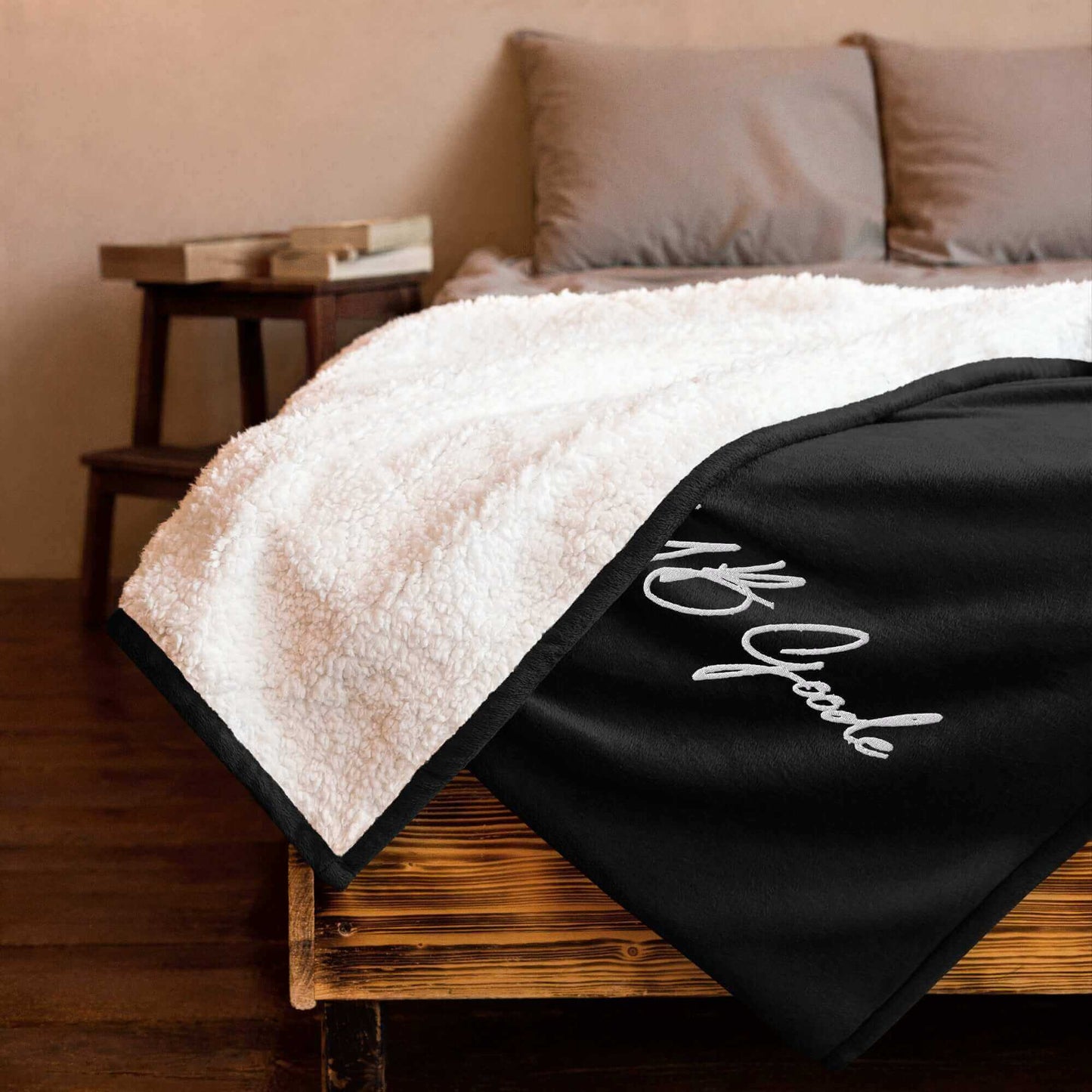 YB Goode Signature Embroidered Sherpa Blanket on a bed, showcasing soft fleece and cozy sherpa fabric.