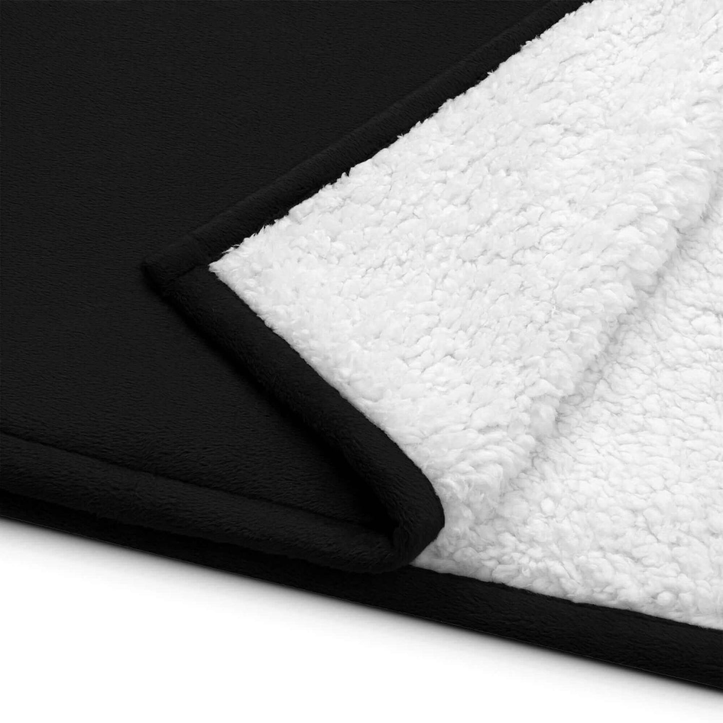 Close-up of YB Goode Signature Sherpa blanket showcasing black fleece and soft white sherpa fabric.