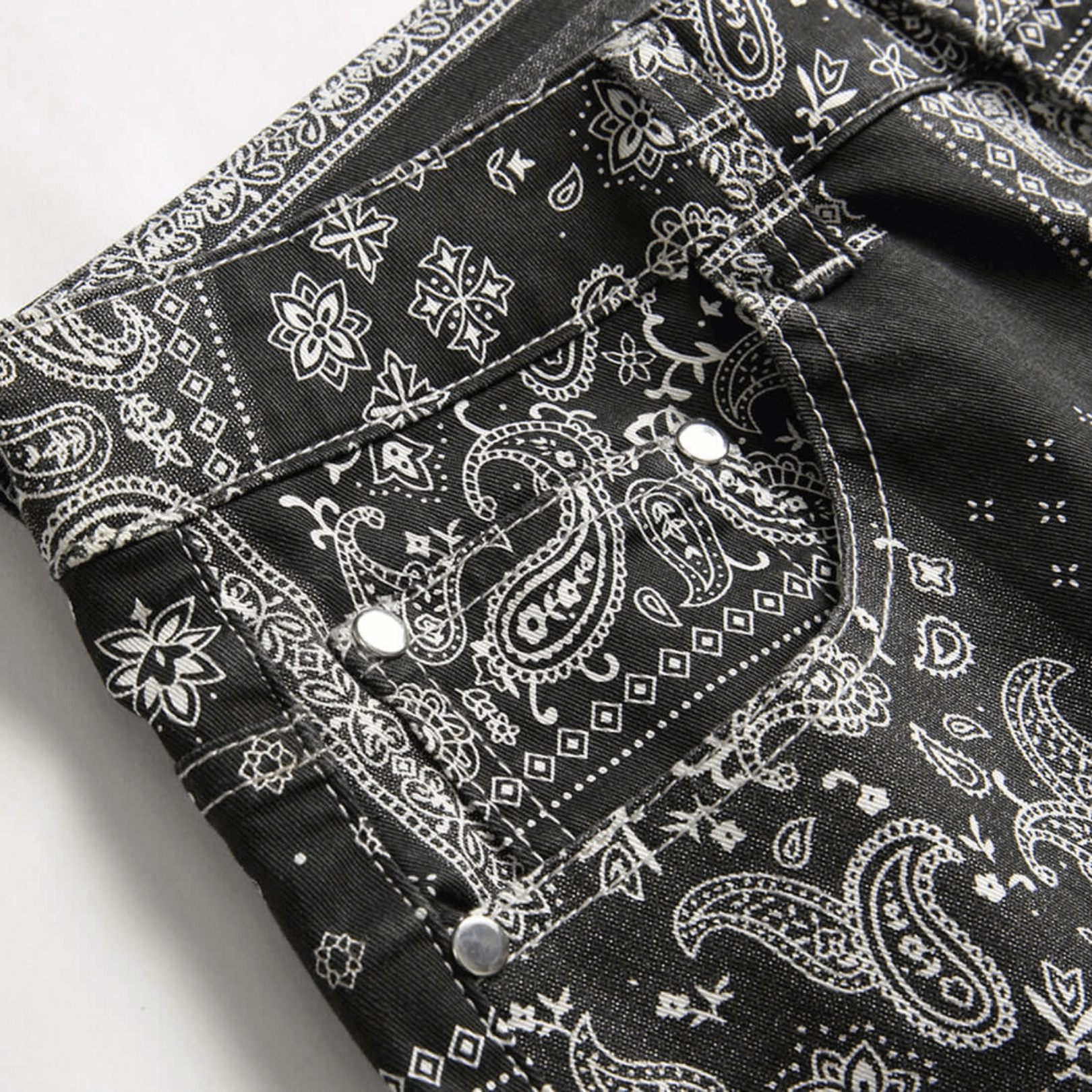 Men's relaxed-fit paisley print denim jeans displaying intricate patterns and premium quality fabric.