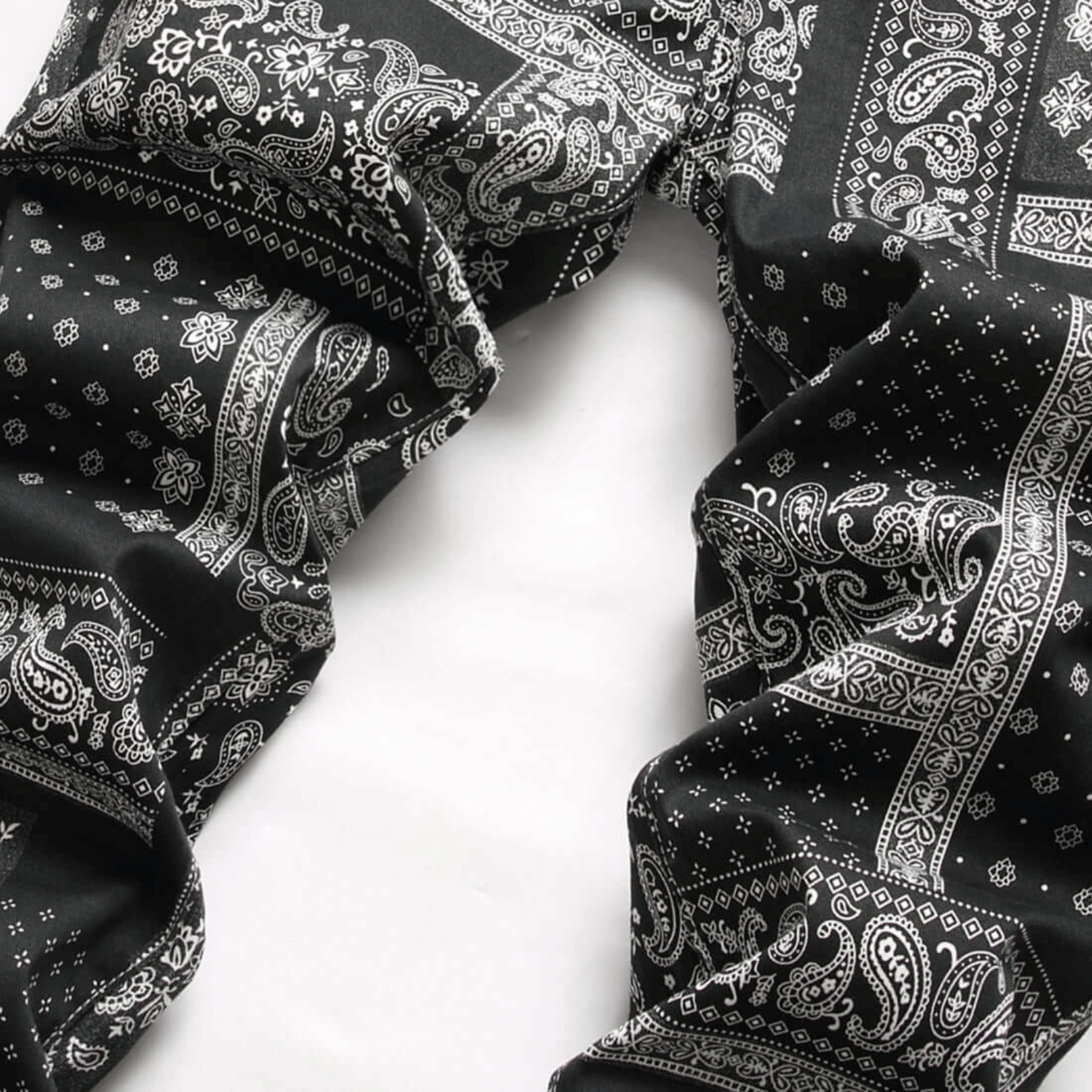Men's relaxed-fit paisley print jeans in black and white, showcasing premium quality denim and retro urban style.