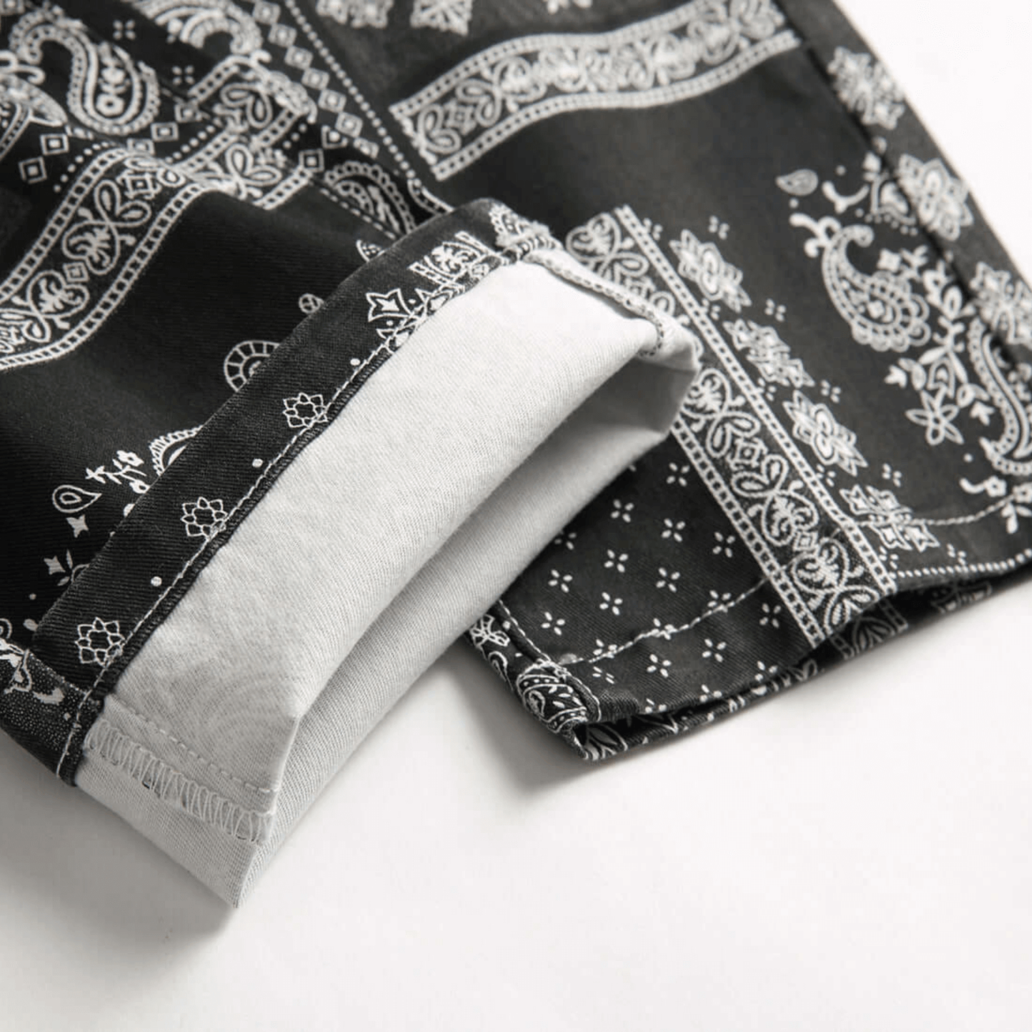 Close-up of relaxed-fit paisley print jeans showing cuff detail in premium quality denim for retro urban style.