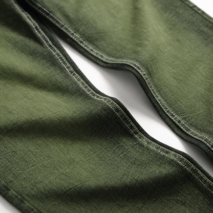Close-up of men's slim-fit green faded designer denim jeans showcasing premium quality and relaxed fit.
