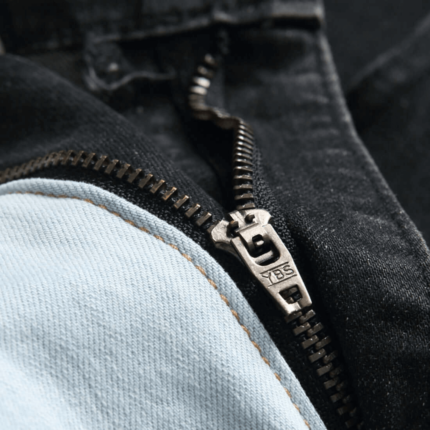 Close-up of zipper on men's slim-fit stretch denim jeans, showcasing premium quality fabric details.